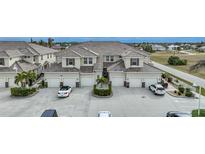 Tan two-story townhouses with tile roofs, two-car garages, and landscaped yards at 17094 Acapulco Rd # 313, Punta Gorda, FL 33955