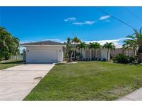 Single-story home with attached garage and lush lawn at 414 Norma Ct, Punta Gorda, FL 33950