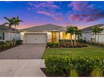 Attractive single-story home with a gray garage door and landscaped yard at 42154 Journey Dr, Punta Gorda, FL 33982