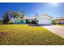 Charming single-story home with a well-manicured lawn, covered porch, and a two-car garage at 10129 Edmonton Ave, Englewood, FL 34224