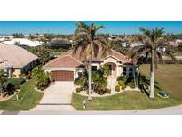 Single-story home with a brown garage door, landscaping, and palm trees at 1110 Rum Cay Ct, Punta Gorda, FL 33950