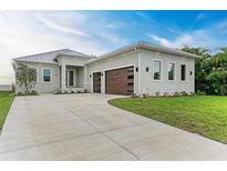 New modern home with attached two-car garage and metal roof at 116 Northshore Ter, Punta Gorda, FL 33980