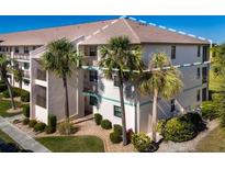 Two-story condo building with palm trees and a landscaped lawn at 175 Kings Hwy # 738, Punta Gorda, FL 33983