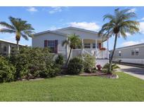 Single-story home with landscaped lawn, porch, and palm trees at 2100 Kings Hwy # 100, Port Charlotte, FL 33980