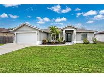 Single-story home with gray exterior, attached garage, and landscaped lawn at 2380 Ann Arbor Rd, North Port, FL 34286