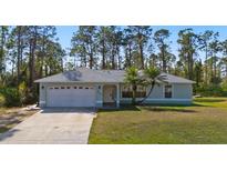 Single story house with a two-car garage and a well-maintained lawn at 2529 Flagami Ln, North Port, FL 34286