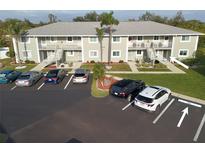 Aerial view of condo building with parking lot and surrounding landscape at 3310 Loveland Blvd # 1604, Punta Gorda, FL 33980