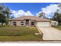 Single-story home with a spacious driveway and well-maintained lawn at 4401 Boeing Ln, North Port, FL 34287