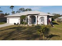 One-story home with light gray exterior, white garage door, and landscaped yard at 4607 Sabrina Ter, North Port, FL 34286