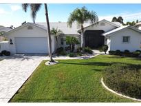 White house with palm trees, large lawn, and a paved driveway at 506 Monaco Dr, Punta Gorda, FL 33950