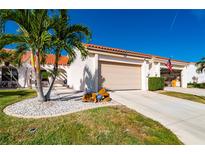 Attractive villa with two-car garage, palm trees, and well-manicured landscaping at 5089 San Rocco Ct, Punta Gorda, FL 33950