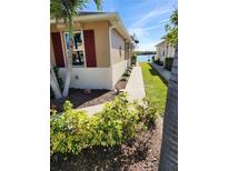 Tan house exterior with red shutters and a walkway leading to a waterfront view at 8773 Tuscany Isles Dr, Punta Gorda, FL 33950