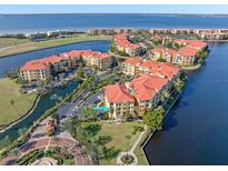 Aerial view of waterfront community with resort-style pool and tennis courts at 98 Vivante Blvd # 98317, Punta Gorda, FL 33950