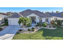 Single-story home with tile roof, landscaping, and driveway at 1023 San Mateo Dr, Punta Gorda, FL 33950