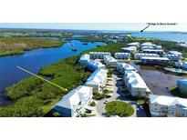 Aerial view of waterfront community with lush landscaping and private boat docks at 10320 Lands End Cir # 47, Placida, FL 33946