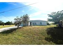 Single-story home with a large front yard and driveway at 12143 & 12151 Dubarry Ave, Port Charlotte, FL 33981