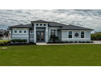 Gray house with a modern design, landscaping, and walkway at 15308 Acorn Cir, Port Charlotte, FL 33981