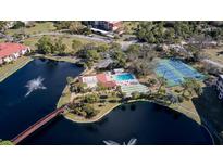 Aerial view showing community pool, tennis courts, and lake at 23465 Harborview Rd # 1006, Punta Gorda, FL 33980