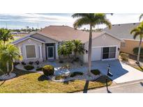 Single-story home with landscaped yard, attached garage, and palm trees at 24060 Buckingham Way, Punta Gorda, FL 33980