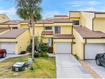 Bright yellow two-story townhome with attached garage and landscaping at 25188 Marion Ave # 1011, Punta Gorda, FL 33950