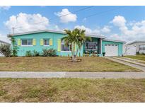 Charming light teal home with yellow shutters, palm trees, and a well-maintained lawn at 4118 Gardner Dr, Port Charlotte, FL 33952