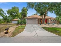 Single-story home with attached garage and landscaped yard at 5208 Griggs Ave, North Port, FL 34291