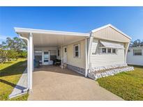 Inviting mobile home exterior featuring a carport and well-maintained landscaping at 5298 Palena Blvd, North Port, FL 34287