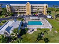 Aerial view of waterfront community with pool, building, and parking at 101 N. Marion Court # 222, Punta Gorda, FL 33950
