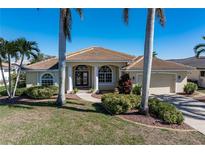Single-story home with tile roof, two-car garage, and landscaped yard at 1131 Via Tripoli, Punta Gorda, FL 33950