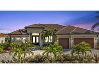 Luxury home with tile roof, two-car garage, and landscaped entry at 1220 Spanish Cay Ln, Punta Gorda, FL 33950