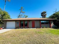 Ranch-style home with attached garage and landscaped yard at 1434 Viscaya Dr, Port Charlotte, FL 33952