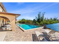 Inviting pool area with patio furniture, overlooking a tranquil canal at 1217 Aqui Esta Dr # 5, Punta Gorda, FL 33950