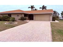 House exterior featuring a brick facade, tile roof, and landscaped yard at 310 Belvedere Ct, Punta Gorda, FL 33950