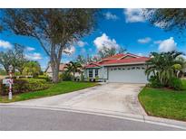 Single-story home with red tile roof, attached garage, and landscaped yard at 3191 Village Ln, Port Charlotte, FL 33953