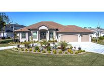 House exterior featuring a large, light-colored house with a tile roof, landscaping, and a three-car garage at 4037 Bal Harbor Blvd, Punta Gorda, FL 33950