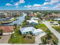 Aerial view of canal-front home with lush landscaping and two-car garage at 840 Via Tunis, Punta Gorda, FL 33950