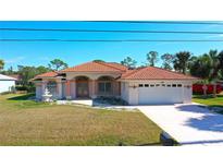 Single-story home with tile roof, fountain, and two-car garage at 108 Mccabe St, Port Charlotte, FL 33953