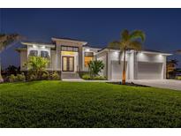 Stunning curb appeal with a modern design, lush lawn, and palm trees at 1380 Willet Ct, Punta Gorda, FL 33950