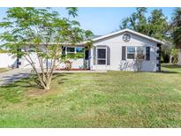 Newly renovated home with a landscaped lawn and driveway at 20430 Dial Ave, Port Charlotte, FL 33952