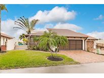 Single-story home with brick driveway, lush landscaping, and a two-car garage at 25188 Marion Ave # 34, Punta Gorda, FL 33950