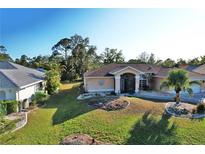 Single-story home with landscaped yard and two-car garage at 2812 Cabaret St, Port Charlotte, FL 33948