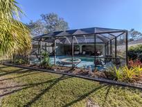 Inviting screened pool area with lush landscaping and patio furniture at 3341 Briant St, North Port, FL 34287