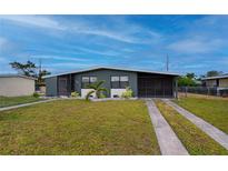 Ranch-style home with gray exterior, landscaping, and double driveway at 350 Duxbury Ave, Port Charlotte, FL 33952