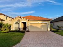 One-story home with tile roof, two-car garage, and landscaped front yard at 4269 River Bank Way, Port Charlotte, FL 33980