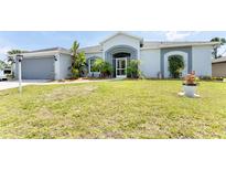 House exterior showcasing a single-story home with a two-car garage and well-maintained lawn at 15105 Aldama Cir, Port Charlotte, FL 33981