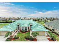 Aerial view of a beautiful home with a green metal roof and lush landscaping at 1551 Atares Dr # 112, Punta Gorda, FL 33950