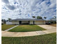 Single-story home with a large yard, attached garage, and solar panels at 258 Beeney Se Rd, Port Charlotte, FL 33952