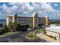 Aerial view of waterfront condo building with parking and landscaping at 101 N Marion Ct # 221, Punta Gorda, FL 33950