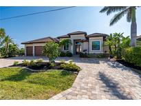 Stunning curb appeal! This home features a tile roof, paver driveway, and lush landscaping at 1406 Mediterranean Dr, Punta Gorda, FL 33950