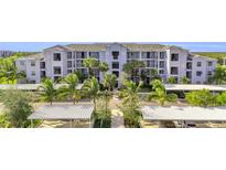 Exterior of a light blue condominium building with palm trees and covered parking at 14091 Heritage Landing Blvd # 121, Punta Gorda, FL 33955